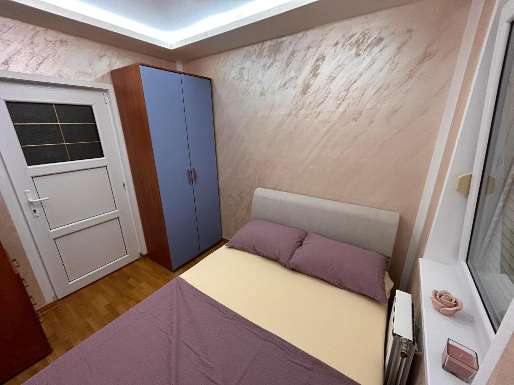 Kleines Zimmer mit einem Bett und einer Tür in der Unterkunft Stan Aleksić in Šabac