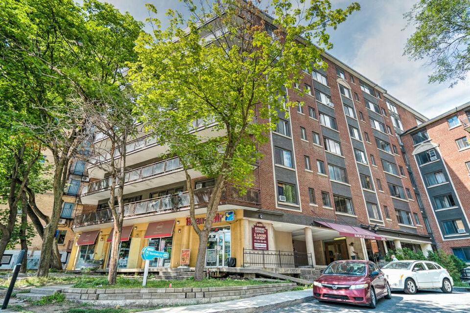 蒙特婁的住宿－Stylish Montreal Apartment: Comfortable Stay in the Golden Square Mile，停在大楼前的红色汽车