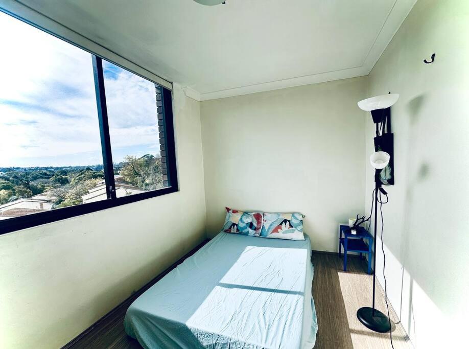 a small bedroom with a bed and a window at Imagine house in Sydney