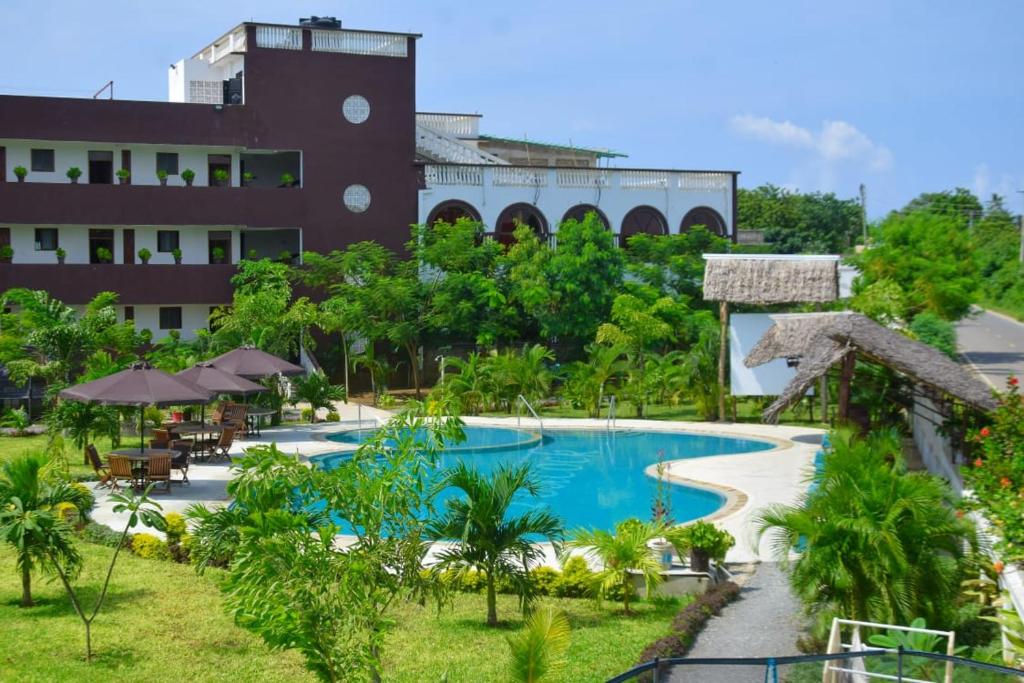 um resort com uma piscina em frente a um edifício em White Peacock Resort Mtwapa em Mtwapa