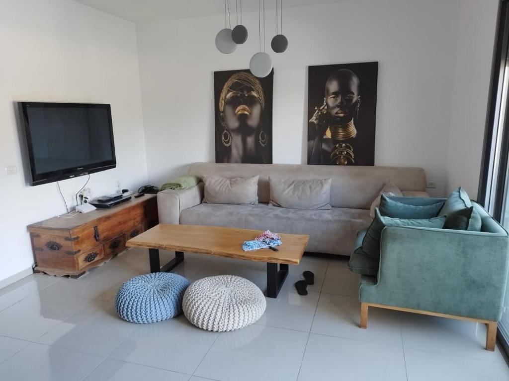 ein Wohnzimmer mit einem Sofa und einem Tisch in der Unterkunft מורדות עין כרם in ‘En Kerem