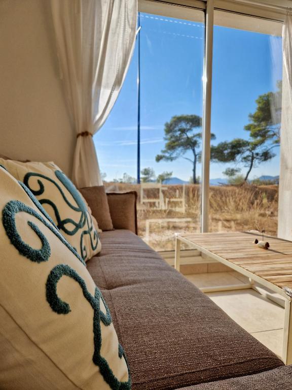 un salon avec un canapé et une grande fenêtre dans l'établissement Les flamants roses de la Capte T3, à Hyères