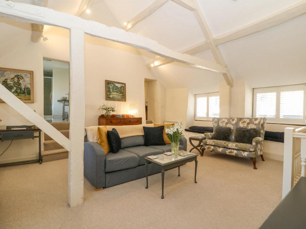 a living room with a couch and a table at The Apartment Stow-on-the-Wold in Stow on the Wold