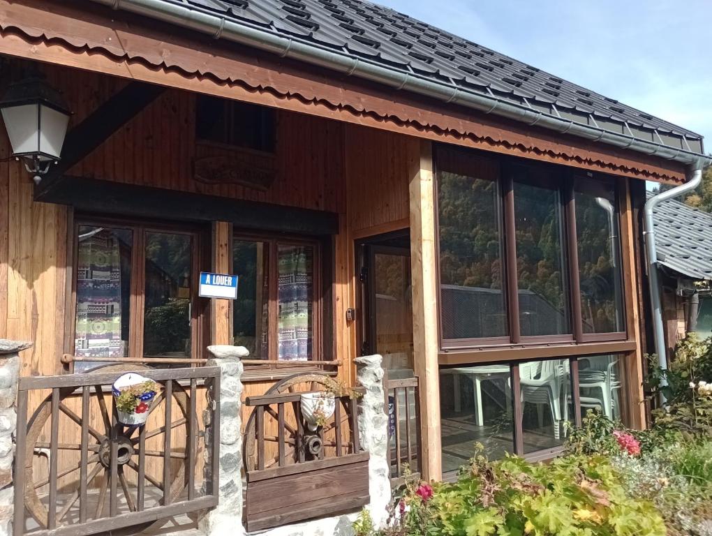 ein Holzhaus mit Glastüren und einer Veranda in der Unterkunft Chalet les Chardons in Celliers