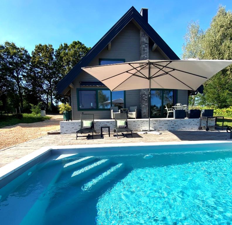 a house with an umbrella next to a swimming pool at River House Moon in Gospić