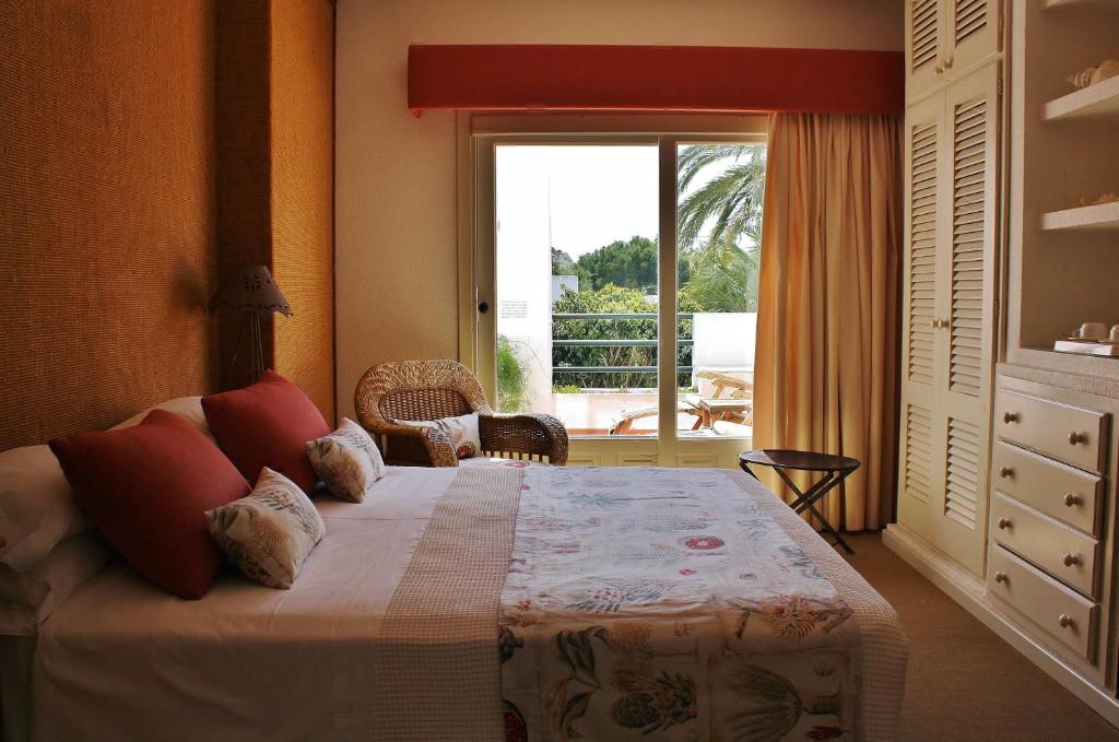 a bedroom with a bed and a large window at miKasa Agua Amarga & SPA in Agua Amarga