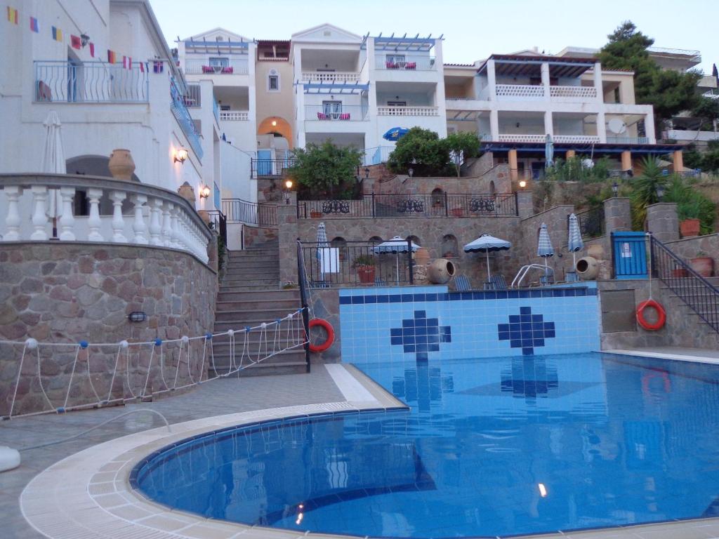 una piscina frente a algunos edificios en KTM Sunny Villas, en Poros