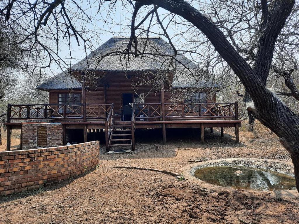 a house with a porch and a wooden deck at Habibi Holiday Home in Marloth Park