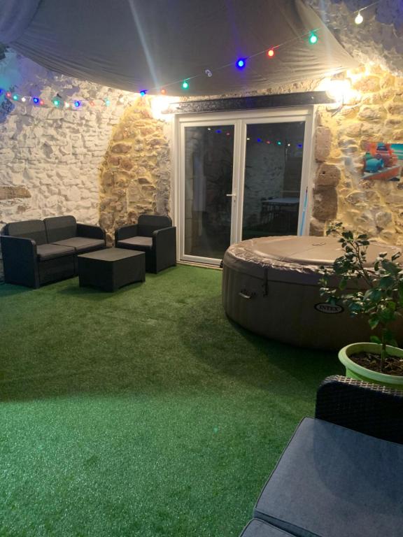 a patio with a spa with green grass at Sab et Mica in Les Fumades-Les Bains