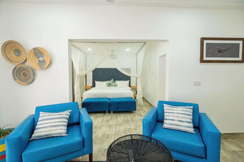um quarto com duas cadeiras azuis e uma cama em Modern deluxe with kitchenette and pool - 2148 em Victoria Falls