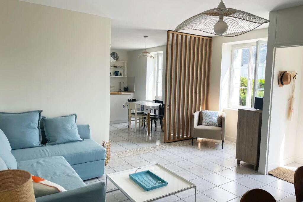 un salon avec un canapé bleu et une table dans l'établissement Maison bigoudène à 5 minutes de Pors Carn, à Penmarcʼh