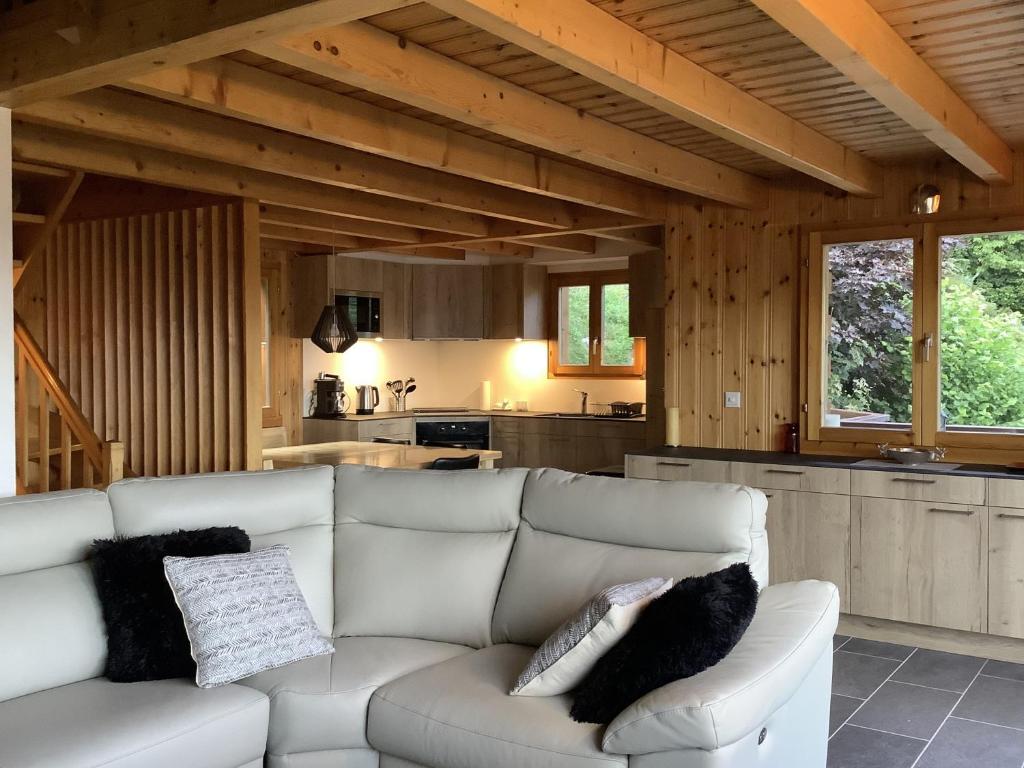 ein Wohnzimmer mit einem weißen Sofa und einer Küche in der Unterkunft Dorril SUNNY & QUIET chalet 10 pers by Alpvision Résidences in Veysonnaz