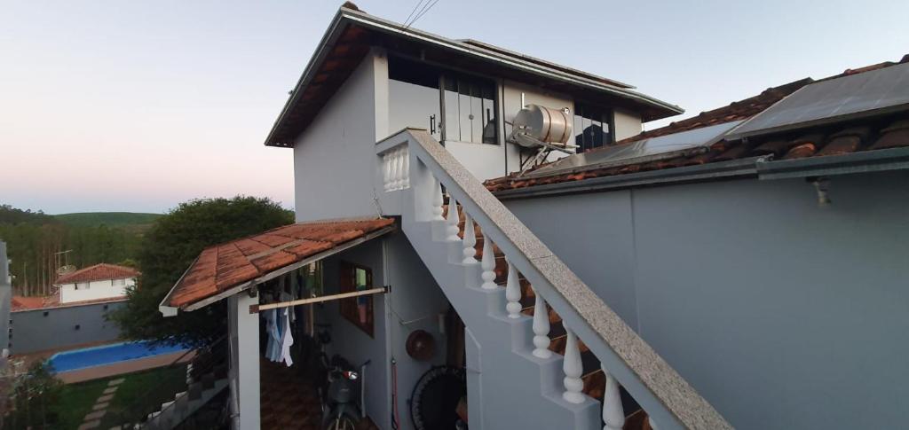 a balcony of a white building with a roof at Casa aconchegante em Catas Altas in Catas Altas