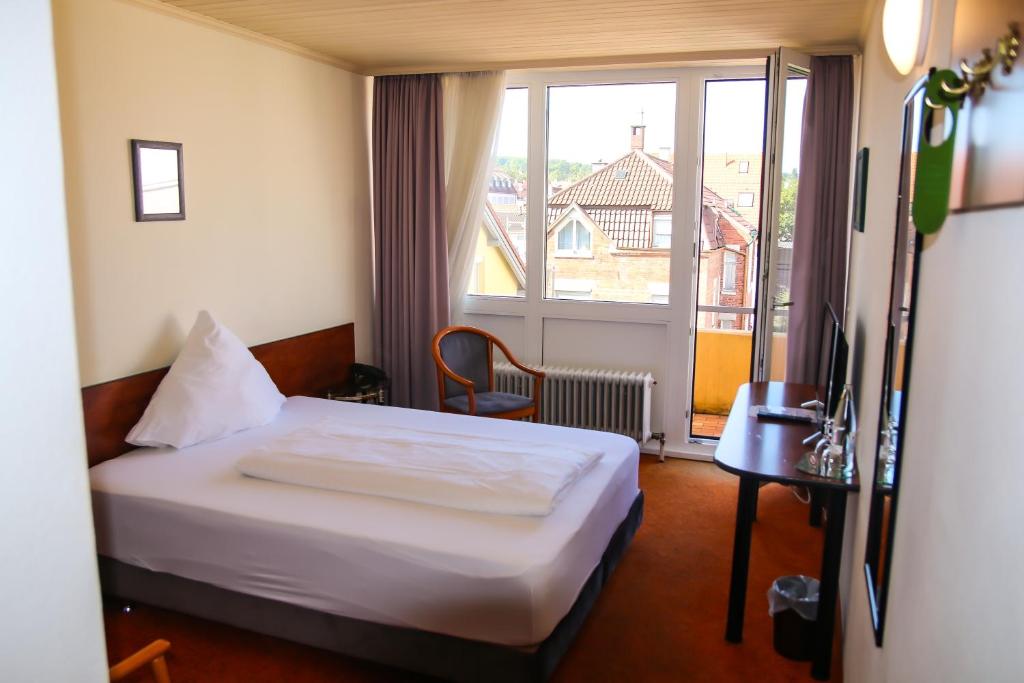 a hotel room with a bed and a window at Hotel Alpha in Stuttgart