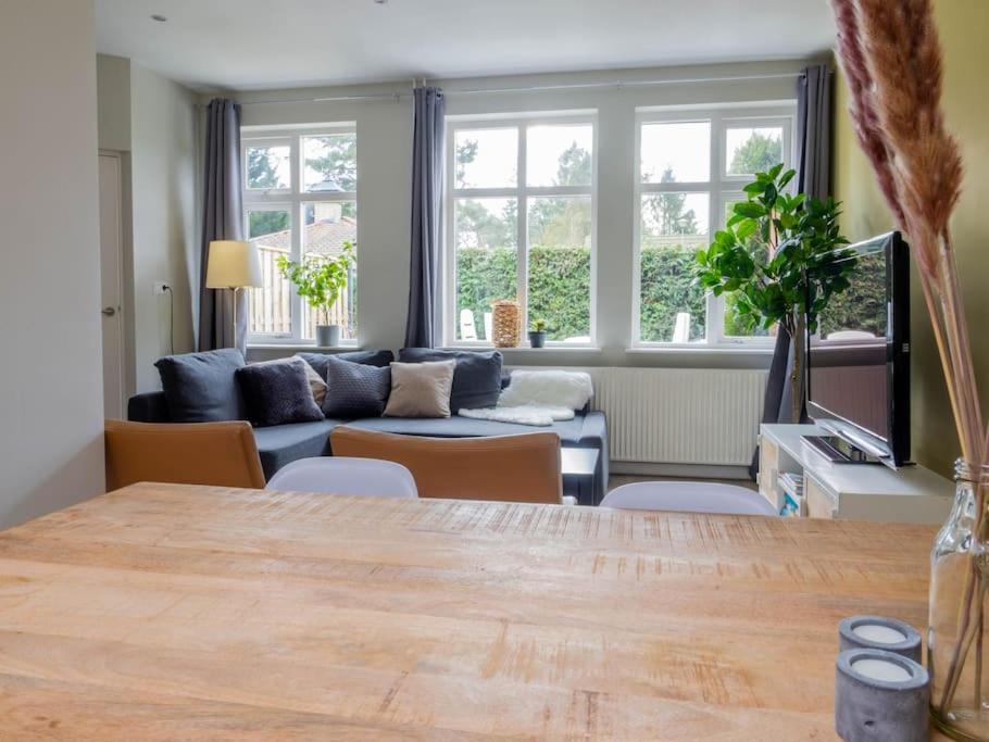 uma sala de estar com uma mesa e um sofá em Ruim en licht bij bos en heide op de Veluwe em Putten