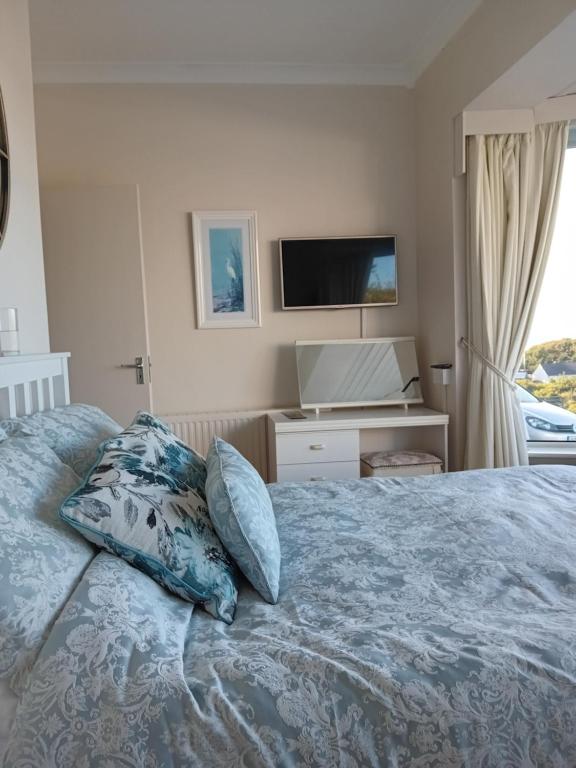 um quarto com uma cama e uma televisão na parede em ATLANTIC VIEW PORTNOO em Clogher