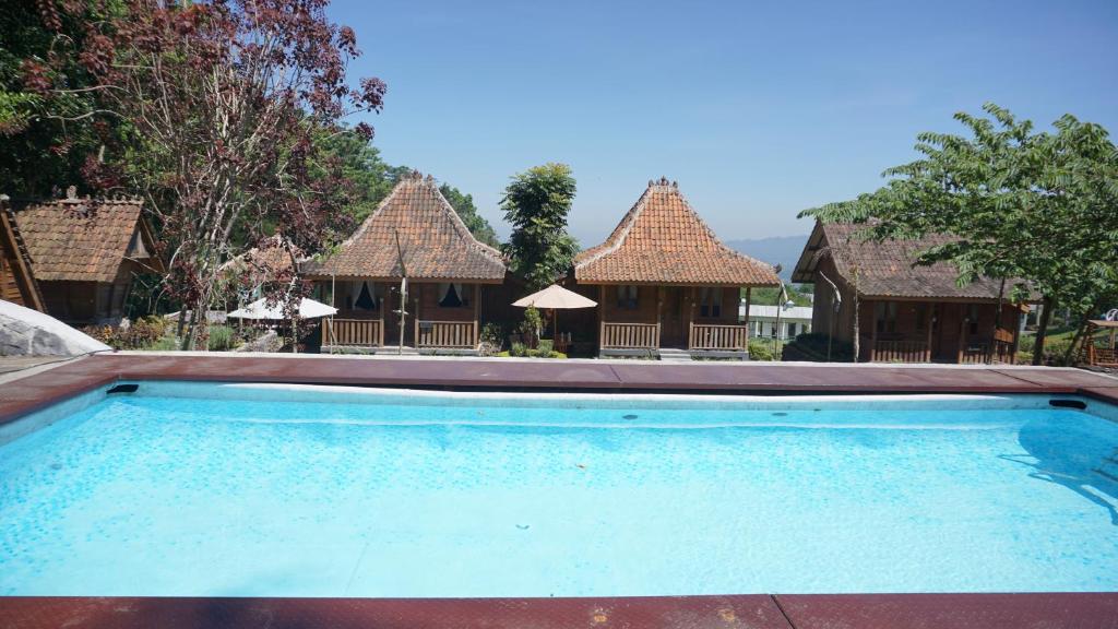 an empty swimming pool in front of some buildings at Le Desa Resort Syariah in Wonosobo