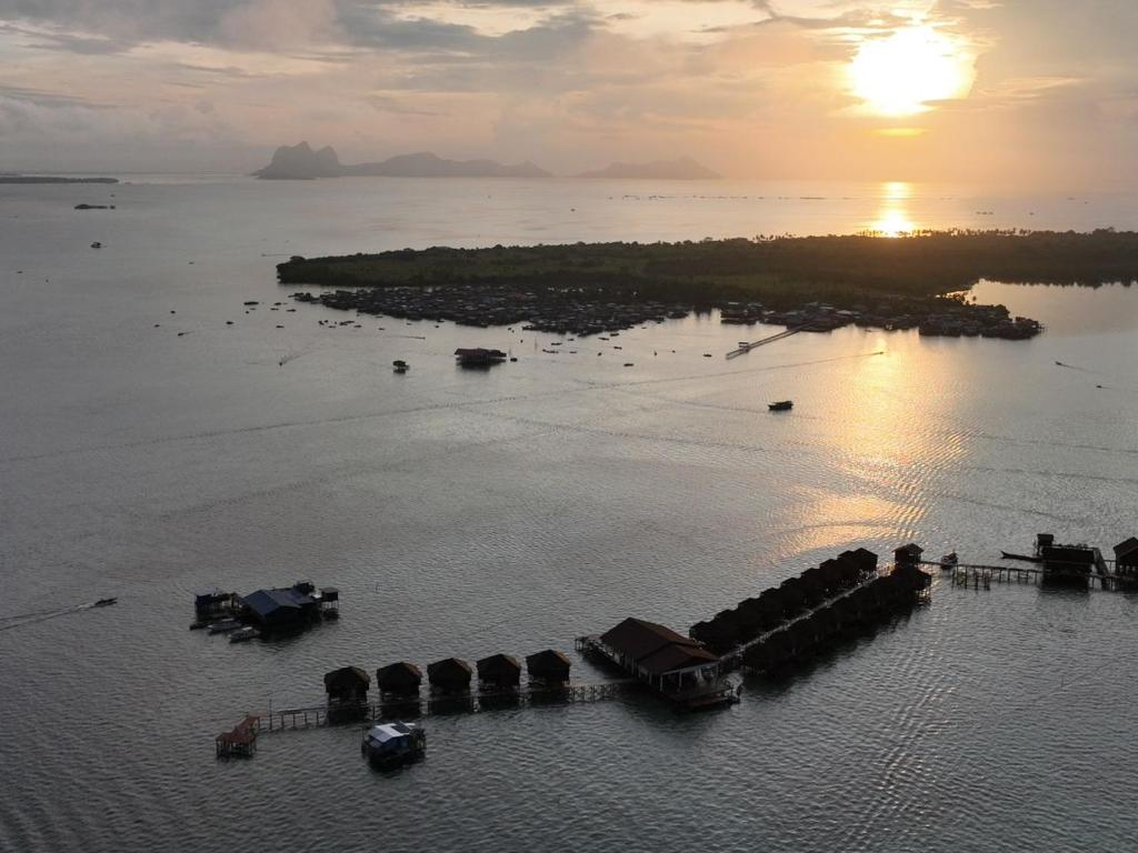 uma ilha num corpo de água com o pôr do sol em Sea Star Resort Semporna em Semporna