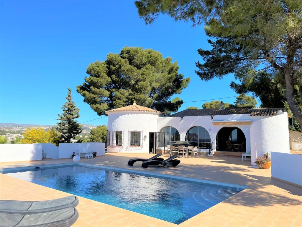 une villa avec une piscine en face d'une maison dans l'établissement Casa Ticciano, à Moraira