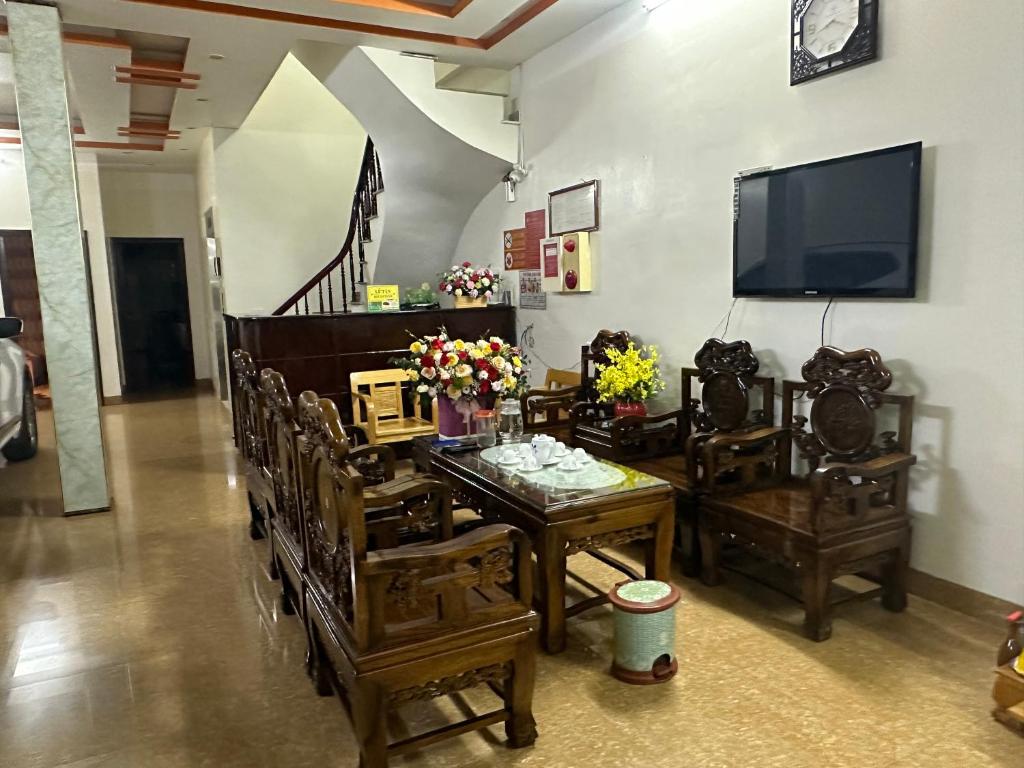 ein Wohnzimmer mit einem Tisch und Stühlen sowie einem TV in der Unterkunft HOTEL HOÀNG GIA in Lai Châu