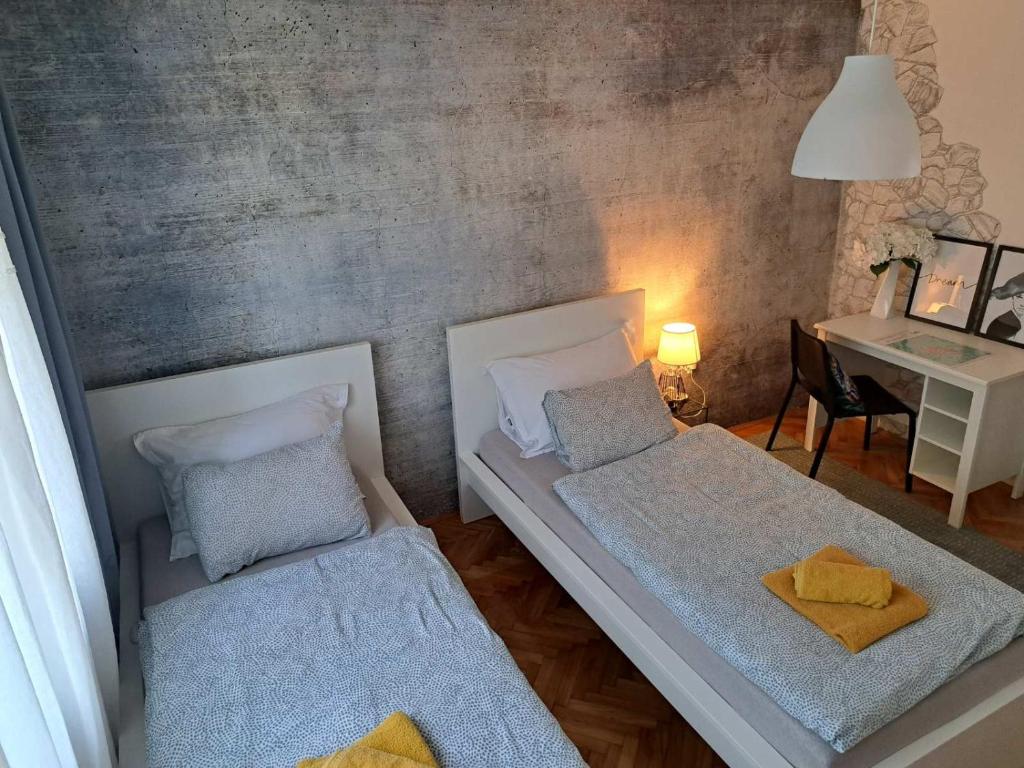 Habitación pequeña con 2 camas y escritorio. en Kuća za odmor Alea Rustica Daruvar en Daruvar