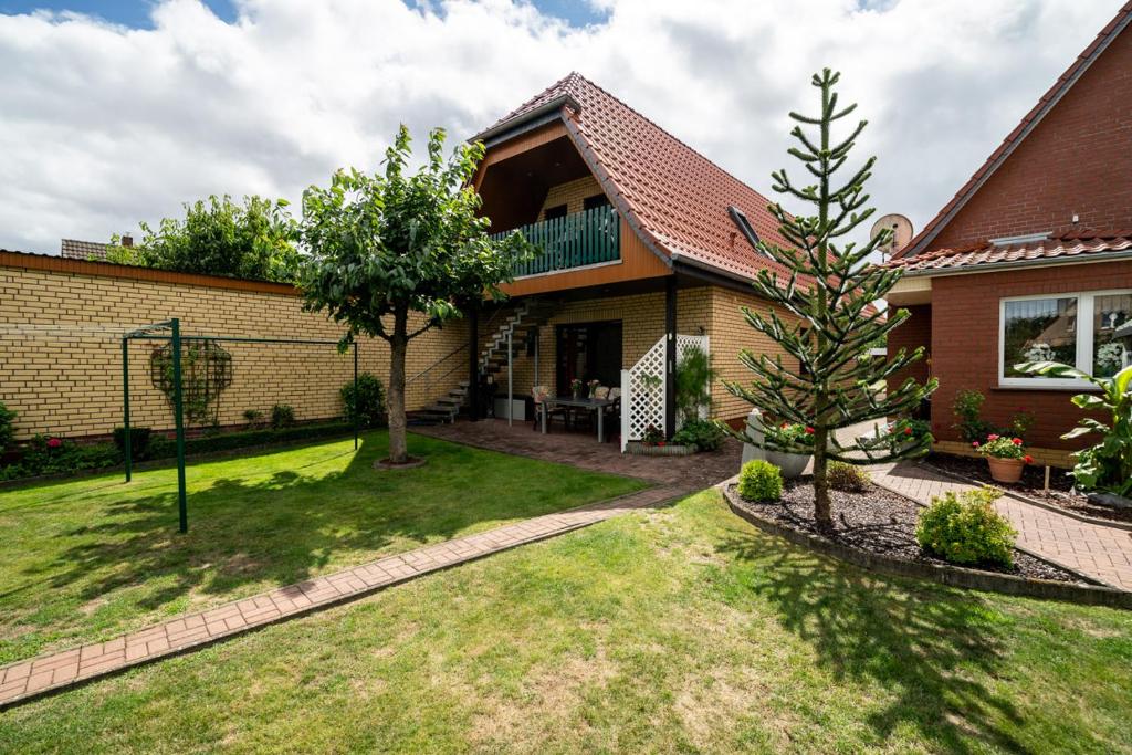 a house with a tree in the yard at Ferienwohnung mit Gartenblick in Rechlin