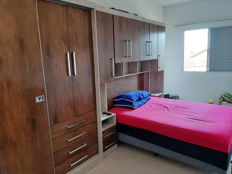 una camera con letto e armadi in legno di Apartamento 1 quarto Mongaguá a Mongaguá