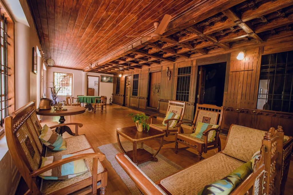 - un salon avec un canapé, une table et des chaises dans l'établissement Meenachil Creek Homestay, à Kottayam