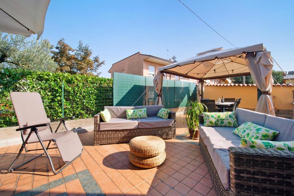 un patio con sofá y sombrilla en Casa Elli, en Osio Sotto