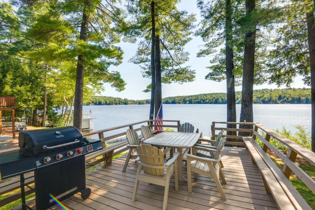 una terraza con mesa, sillas y parrilla en Lakefront Cabin with Canoes, 7 Mi to Mount Sunapee!, en Sunapee