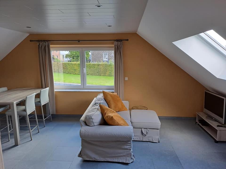 a living room with a couch and a table and a window at La Ferme Villa in Bastogne
