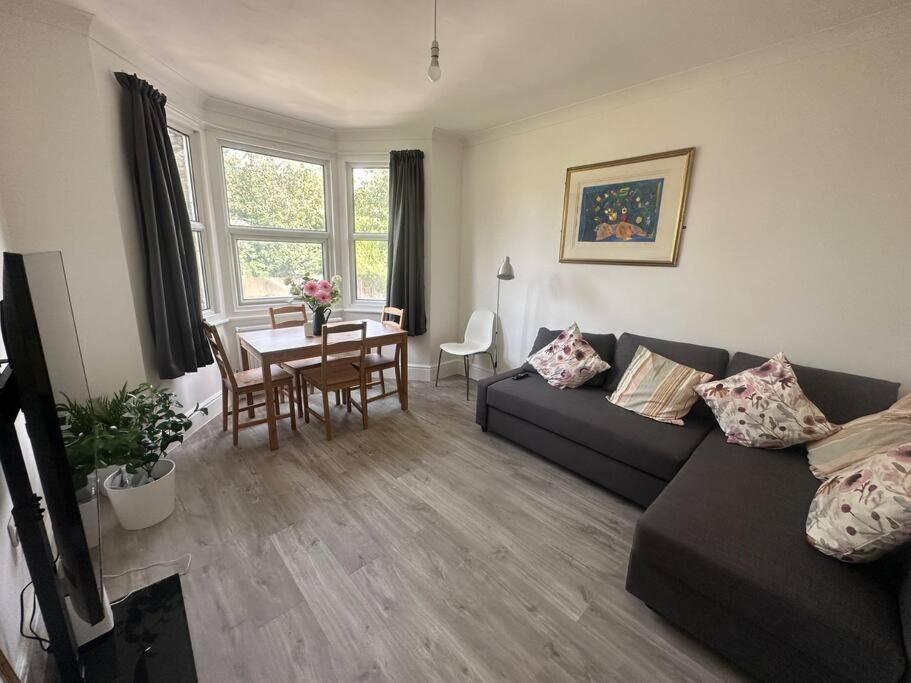 Modern 2 bedroom flat, SE6 في Catford: غرفة معيشة مع أريكة وطاولة