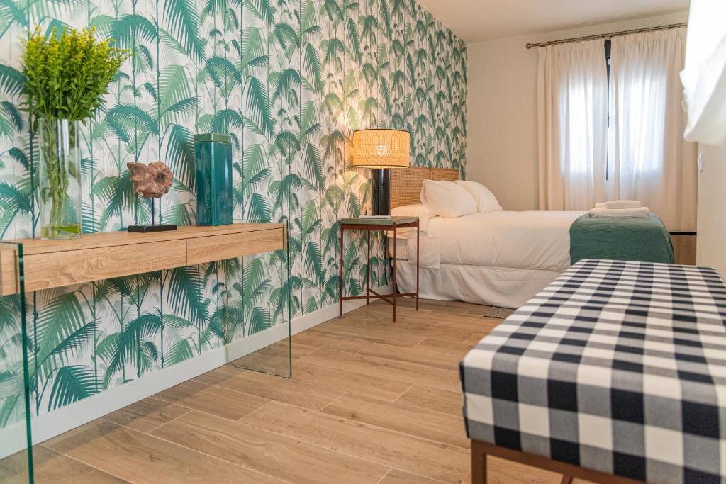 a room with a bed and a green and white wallpaper at La Casa del Pintor Apartments in Seville