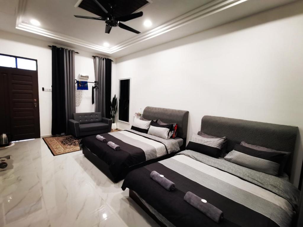 sypialnia z 2 łóżkami i wentylatorem sufitowym w obiekcie MINI HOTEL CONCEPT w mieście Kuala Terengganu