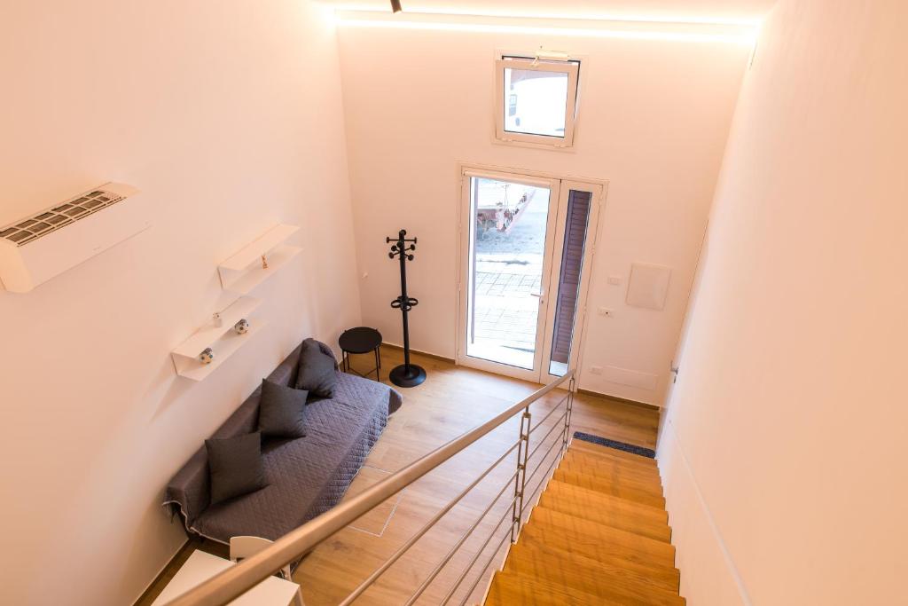 un escalier avec un canapé bleu et une fenêtre dans l'établissement White Home, à Castellammare del Golfo