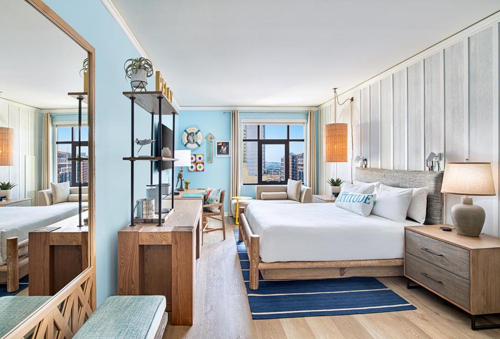 a bedroom with two beds and a living room at Margaritaville Hotel San Diego Gaslamp Quarter in San Diego