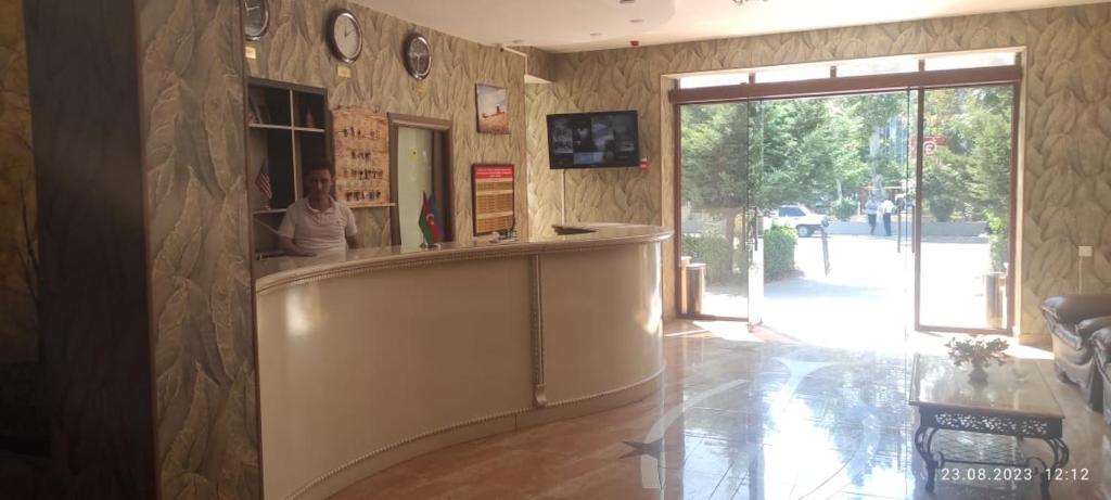 a woman sitting at a counter in a lobby at Chinar in Göyçay