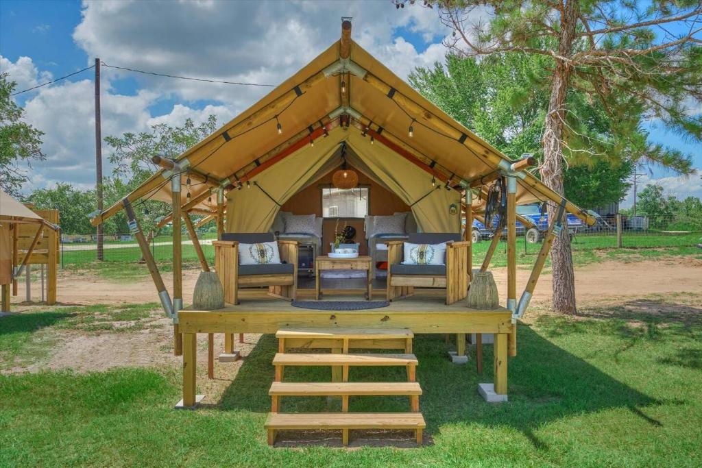 einen Pavillon mit einem Tisch und Stühlen in der Unterkunft Hive Check - Safari Tent - BeeWeaver Honey Farm in Navasota