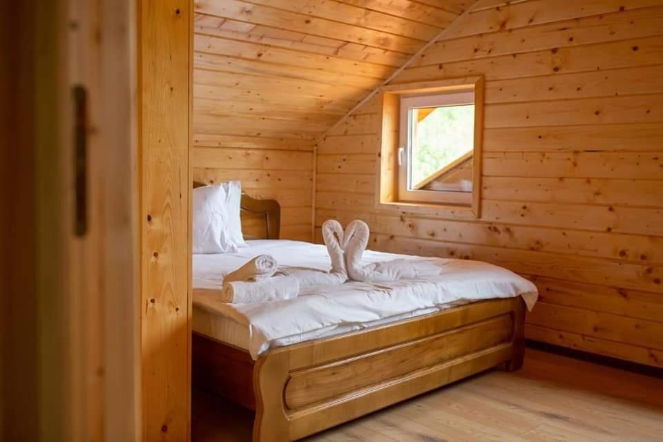 a bedroom with a bed in a log cabin at Cabana AFTER HILL in Cluj-Napoca