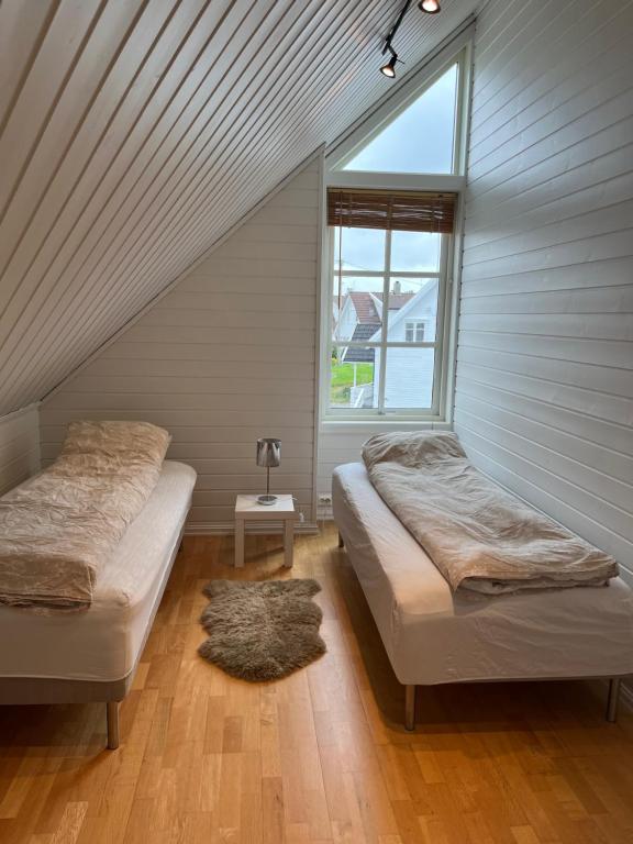 um quarto no sótão com 2 camas e uma janela em Lovely apartment in maritime surroundings near Stavanger em Stavanger