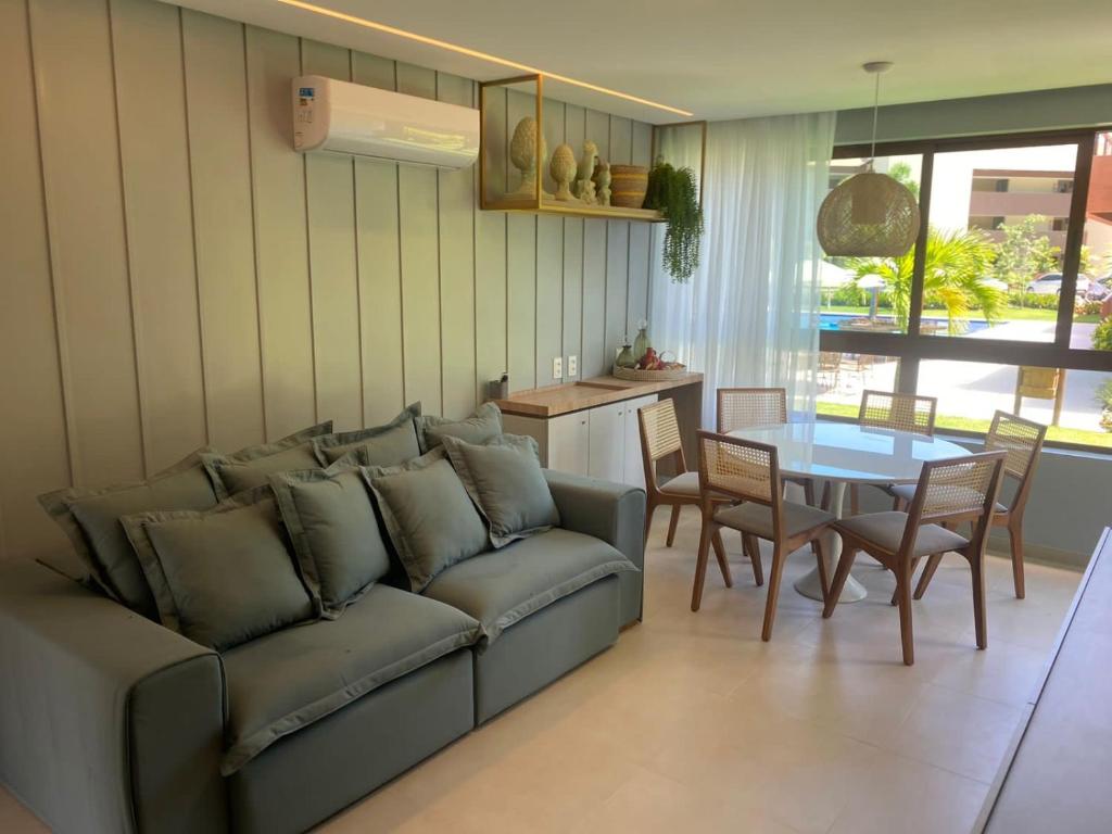 ein Wohnzimmer mit Sofa und Tisch in der Unterkunft Flat térreo luxo 2qts Carneiros ao lado da igrejinha in Tamandaré