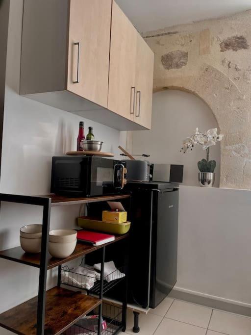 a kitchen with a black refrigerator and a microwave at Bel appartement au centre de Branne in Branne