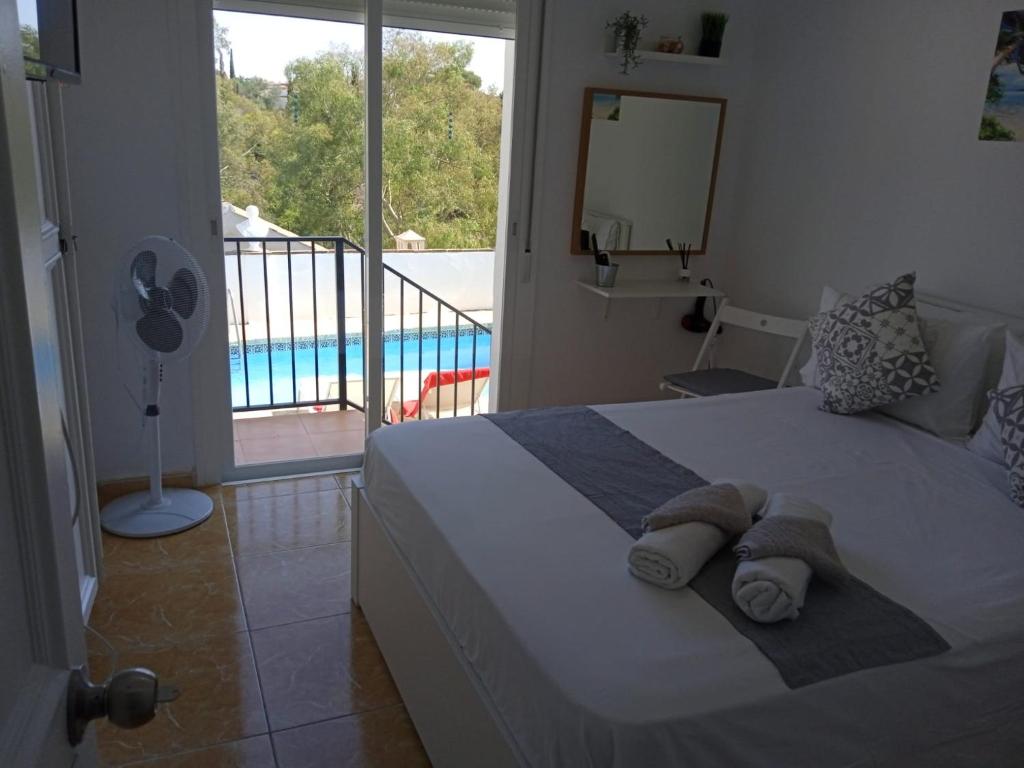 a bedroom with a bed with a view of a pool at Tropical Suite in Benalmádena