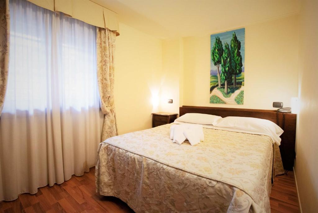 Postel nebo postele na pokoji v ubytování Hotel Arcobaleno Siena