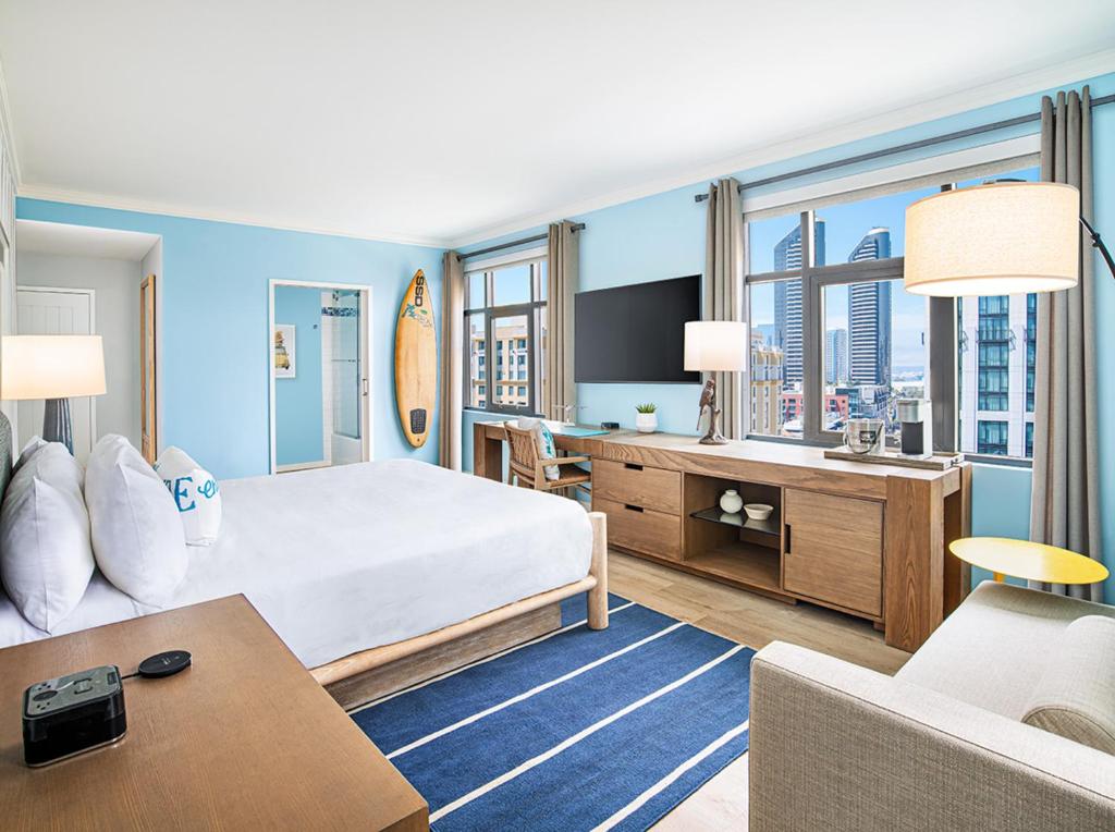 a hotel room with a large bed and a desk at Margaritaville Hotel San Diego Gaslamp Quarter in San Diego