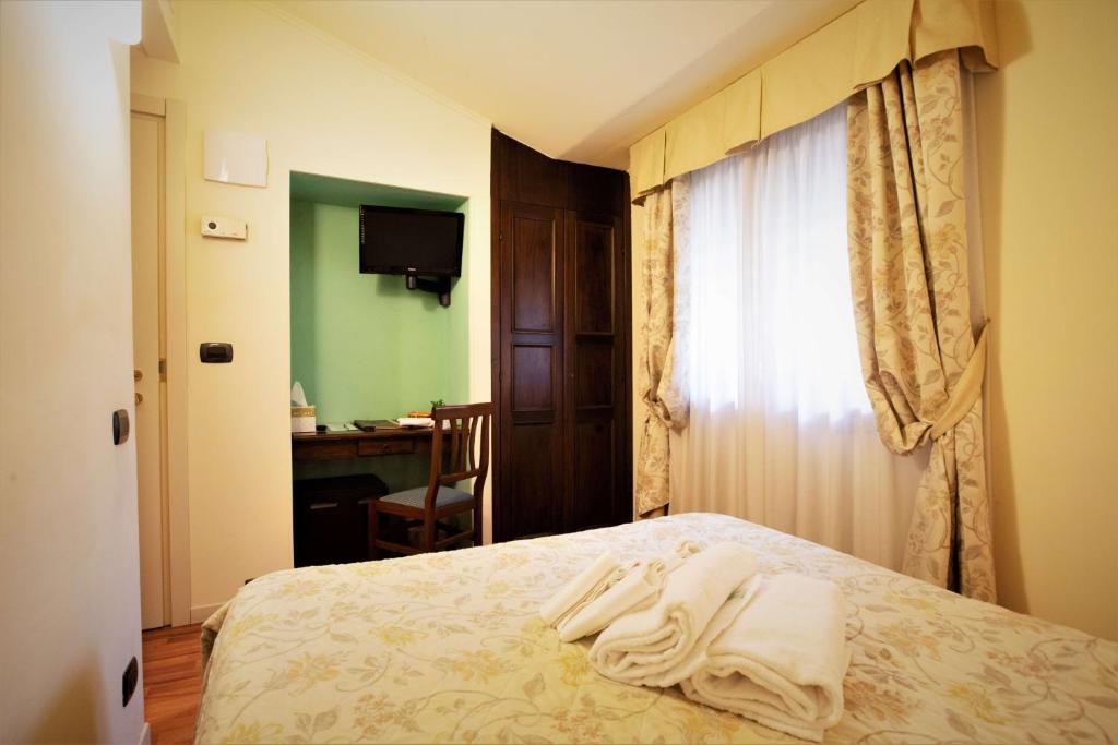 Postel nebo postele na pokoji v ubytování Hotel Arcobaleno Siena