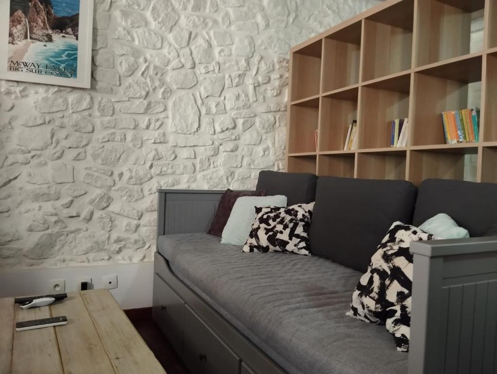 - un canapé dans une chambre dotée d'un mur en pierre dans l'établissement Studio - hypercentre - WIFI et Clim, à Toulon