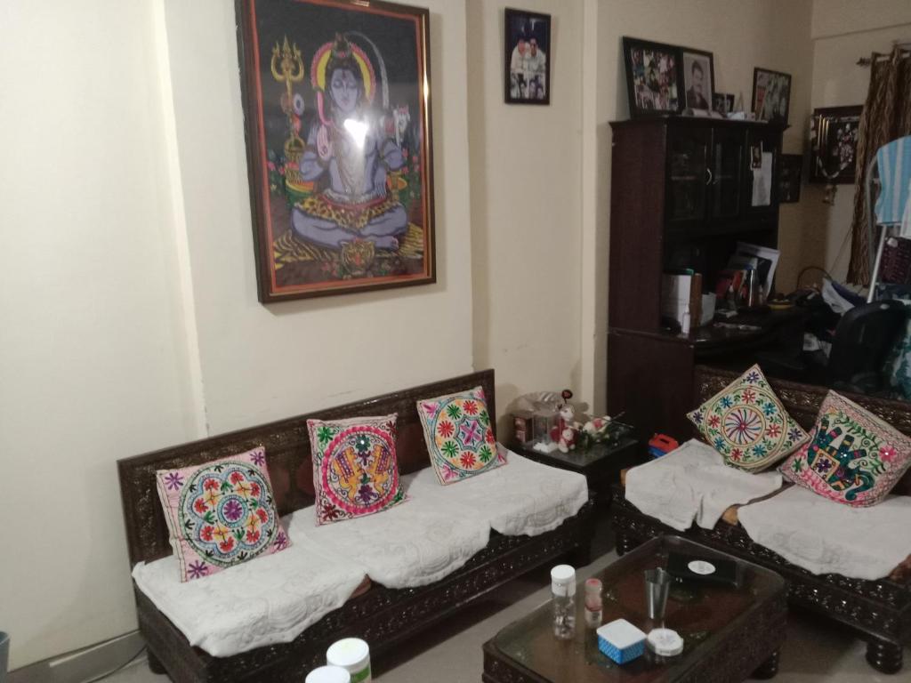 a living room with two couches with pillows at Aayushman Homes in Bangalore