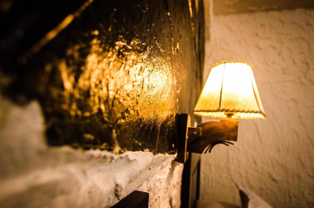 una lámpara fijada a una pared con una luz encendida en KW HOTEL, en Uyuni