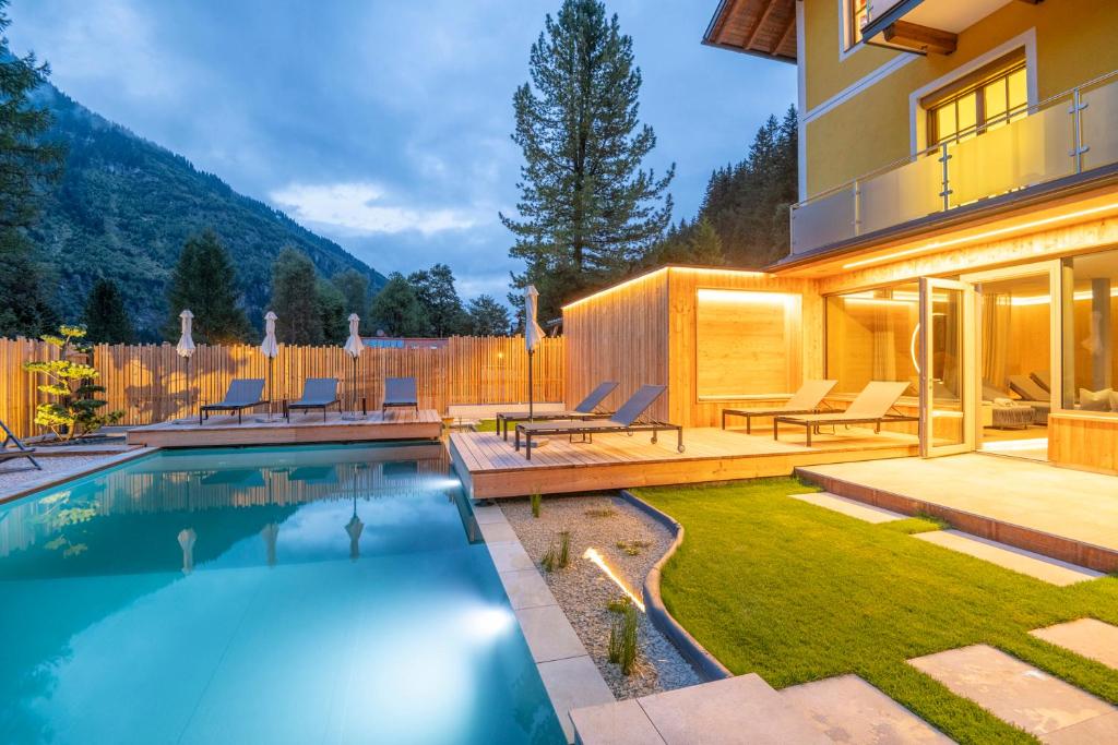 a backyard with a swimming pool and a house at Appartementhaus zur Post in Bad Gastein